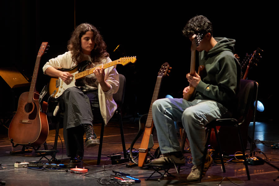 Dois alunos adolescentes com guitarra elétrica e baixo, pedaleira no chão, Recital de Natal 2024