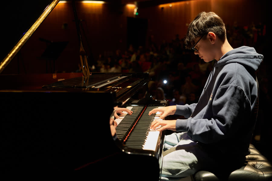 Adolescente ao piano de cauda, plateia cheia e um telemóvel a filmar, Recital de Natal 2024